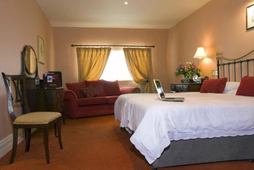 a hotel room with a bed with a laptop on it at The Listowel Arms Hotel in Listowel