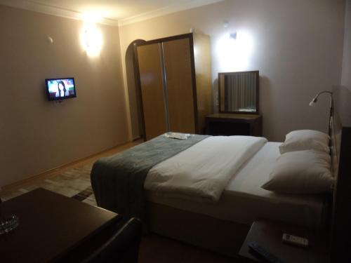 a hotel room with a bed and a tv at Perla Hotel in Dikili