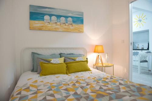 a bedroom with a bed and a painting on the wall at Tropical house in Sesimbra