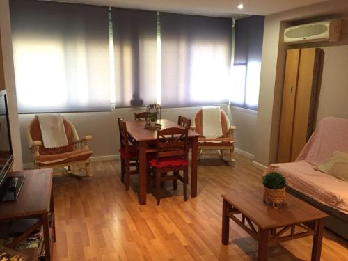 a living room with a table and chairs and a couch at Apartamento Cabañal in Cullera