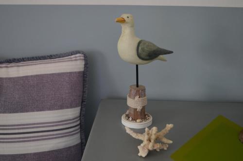 a toy duck sitting on a table next to a pillow at Les appartements de la Villa Beida in Oualidia