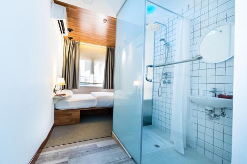 Un baño con ducha de cristal y lavabo. en Far Home Bernabeu, en Madrid
