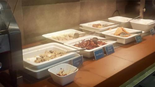 a table with several trays of food on it at Hotel Djerba Orient in Mezraya