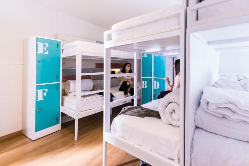 1 dormitorio con literas blancas y espejo en Far Home Bernabeu, en Madrid