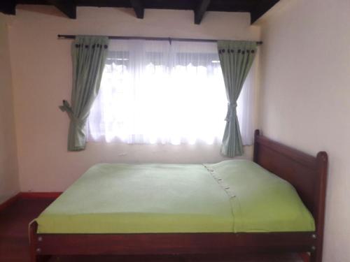 a bed in a bedroom with a window at Las Mercedes Finca Cafetera in Cumaca