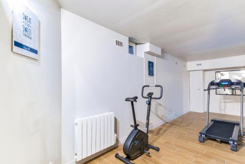a room with a treadmill and an exercise bike at Sweett - Villa Montorgueil in Paris