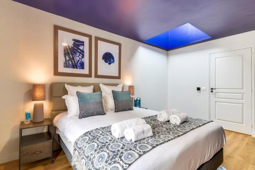 a bedroom with a large bed with towels on it at Sweett - Villa Montorgueil in Paris