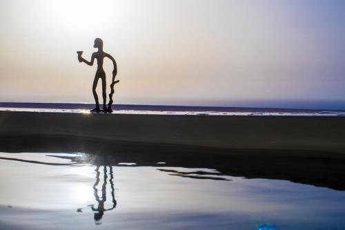 a silhouette of a person standing on the beach at Art Maisons Oia Castle in Oia