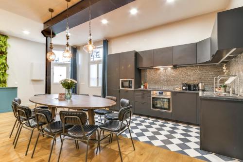 an open kitchen with a wooden table and chairs at Sweett - Villa Montorgueil in Paris