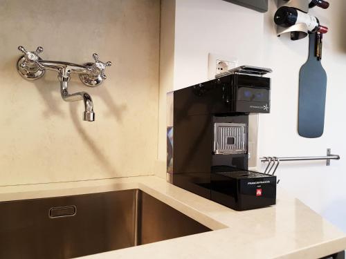 a kitchen with a microwave oven and a sink at Deodato Apartments in Tropea