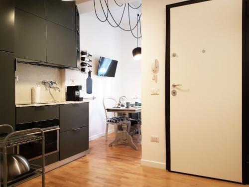 a kitchen with black cabinets and a table at Deodato Apartments in Tropea