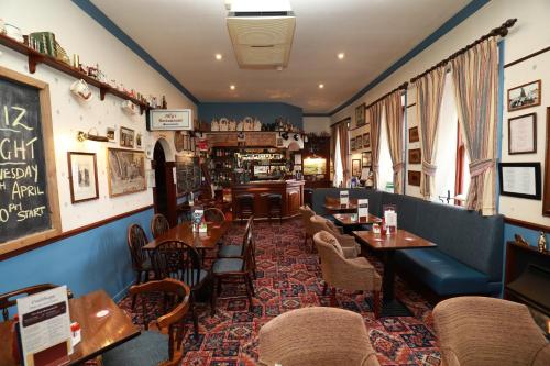 um restaurante com mesas e cadeiras e um bar em The Famous Star Hotel Moffat em Moffat