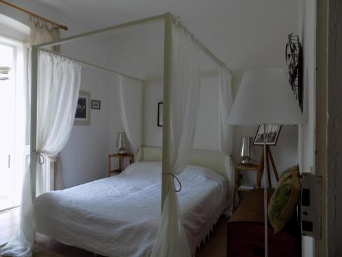 sypialnia z łóżkiem z baldachimem i oknem w obiekcie Casa Giglio w mieście Carloforte