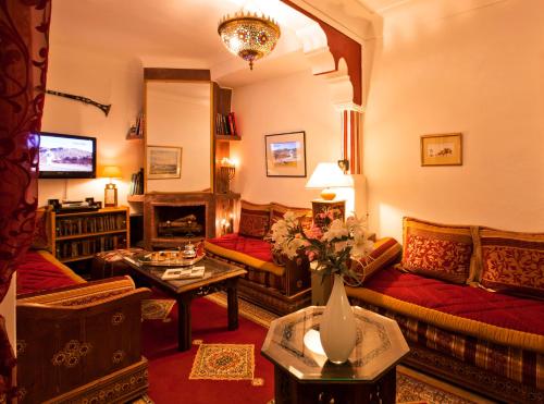 ein Wohnzimmer mit einem Sofa und einem Tisch in der Unterkunft Riad Cherihane in Marrakesch