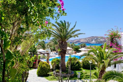 a view of a resort with palm trees and a swimming pool at Dionysos Seaside Resort Ios in Mylopotas