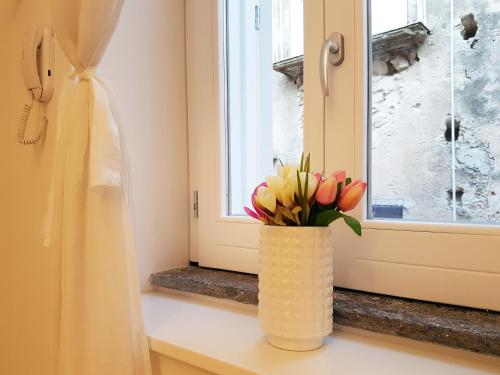 a vase with flowers sitting on a window sill at Deodato Apartments in Tropea