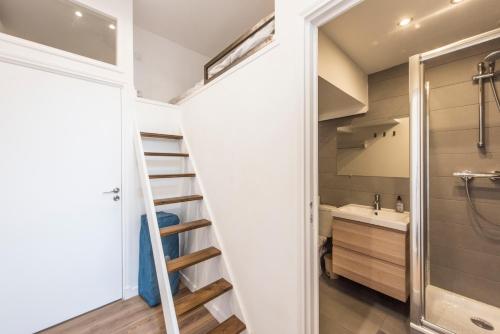 uma escada que leva a uma casa de banho com um lavatório e um WC em F2 mezzanine centre ville 1 min de la mer em Saint-Raphaël
