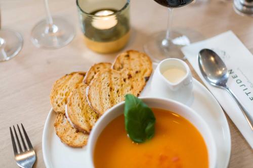 a plate with a bowl of soup and some bread at Hotel - Restaurant De 4 Jaargetijden in Epen