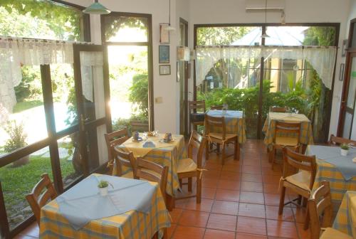 a restaurant with tables and chairs in a room at Posada del Angel in Colonia del Sacramento