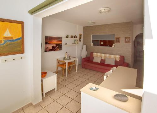 a living room with a red couch and a table at Casa Maralba Famara in Famara