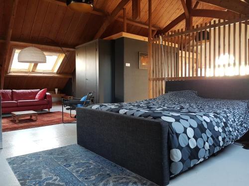 een slaapkamer met een bed en een woonkamer bij Hofstede Prinsland in Kortgene