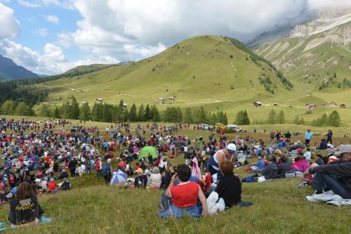 a large crowd of people sitting in the grass at Garni Miravalle in Moena