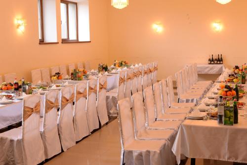 a row of tables and chairs with white table cloth at Odzun Hotel in Alaverdi
