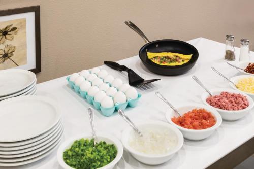 a table topped with plates and bowls of food at Country Inn & Suites by Radisson, St Petersburg - Clearwater, FL in Pinellas Park