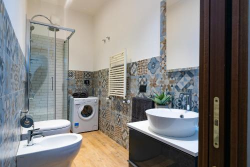 uma casa de banho com um lavatório e uma máquina de lavar roupa em La Casetta di Porta Romana em Milão