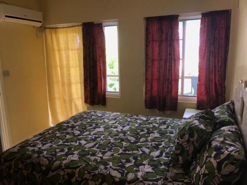a bedroom with a bed and two windows at Marvey's Place in Castries