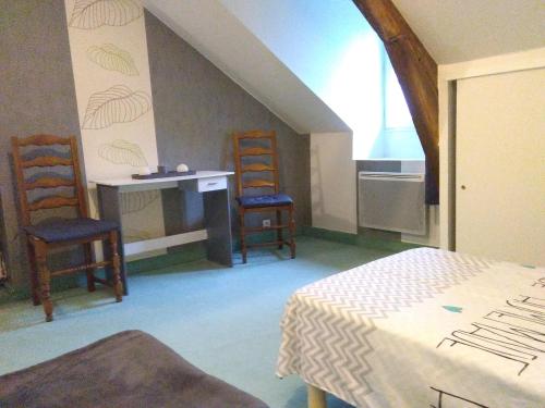 a room with two chairs and a desk and a bed at la longere de Lor'Phée in Chantepie