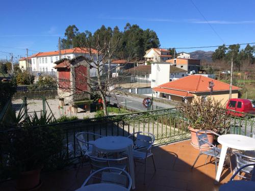 a balcony with tables and chairs and a view of a city at hostel do Ermal in Vieira do Minho