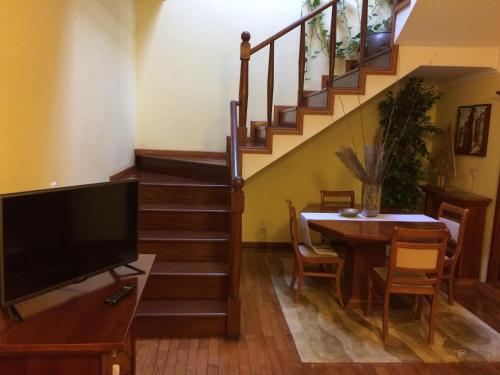 a living room with a television and a table and a staircase at hostel do Ermal in Vieira do Minho