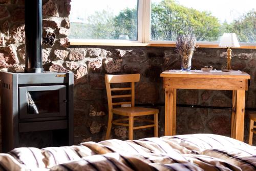 a room with a stove and a table and a chair at La Calandria Casa de Campo in Puerto Madryn