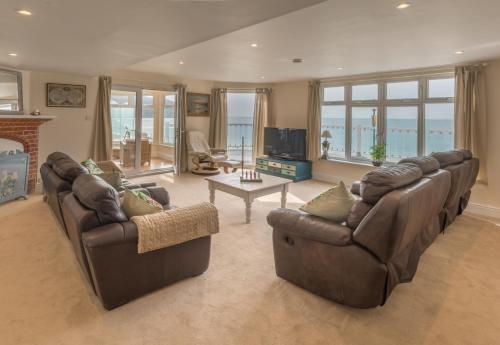 a living room with two couches and a fireplace at Beachside Apartment, 2 Pilots Point in Totland