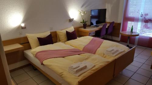 a bedroom with a large bed with towels on it at Hotel Lötschberg in Spiez