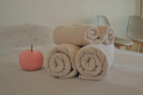 a pile of towels and an apple on a bed at Studio Lovely Sea in Le Barcarès