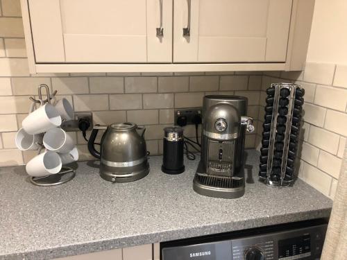 a kitchen counter top with a coffee maker and appliances at Camerton Inn Cottage in Bath