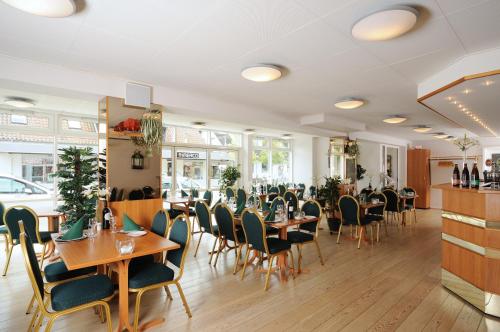 a restaurant with tables and chairs in a room at Hotel Vildbjerg in Vildbjerg