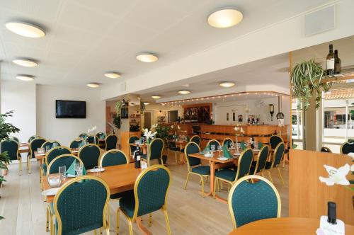 a dining room with wooden tables and chairs at Hotel Vildbjerg in Vildbjerg