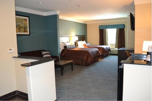 a hotel room with two beds and a couch at Red River Inn and Suites in Thackerville