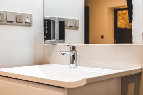 a bathroom with a sink and a mirror at SILESIA Apartment in Ostrava