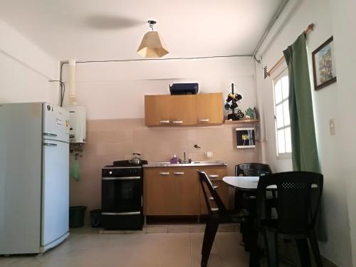 cocina con nevera blanca y mesa en Departamento Alvarado en Salta