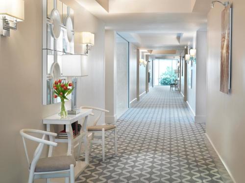 a corridor of a hotel hallway with a table and chairs at Grand Beach Hotel Bay Harbor in Miami Beach