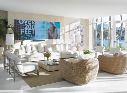 a living room with white furniture and wicker chairs at Grand Beach Hotel Bay Harbor in Miami Beach