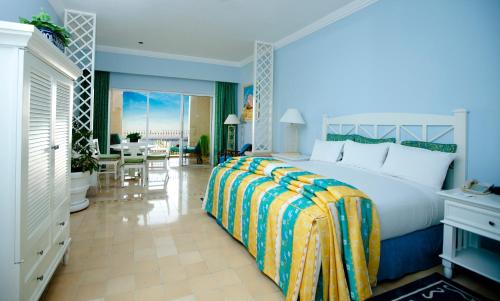 a bedroom with a large bed and a dining room at Pueblo Bonito Emerald Bay Resort & Spa - All Inclusive in Mazatlán