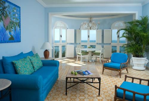 a living room with a blue couch and a table at Pueblo Bonito Emerald Bay Resort & Spa - All Inclusive in Mazatlán