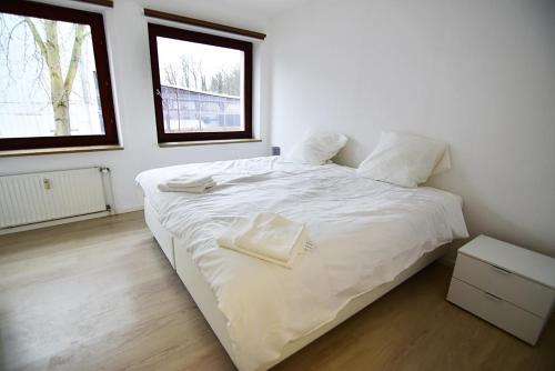 a white bedroom with a large bed with white sheets at Monteurwohnung Satzvey in Mechernich