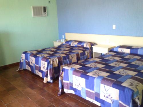 two beds in a room with blue walls at Dorados Conventions & Resort in Oaxtepec