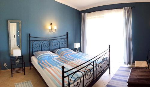 - une chambre avec un lit aux murs bleus et une fenêtre dans l'établissement Ferienhaus am Glindower See, à Petzow